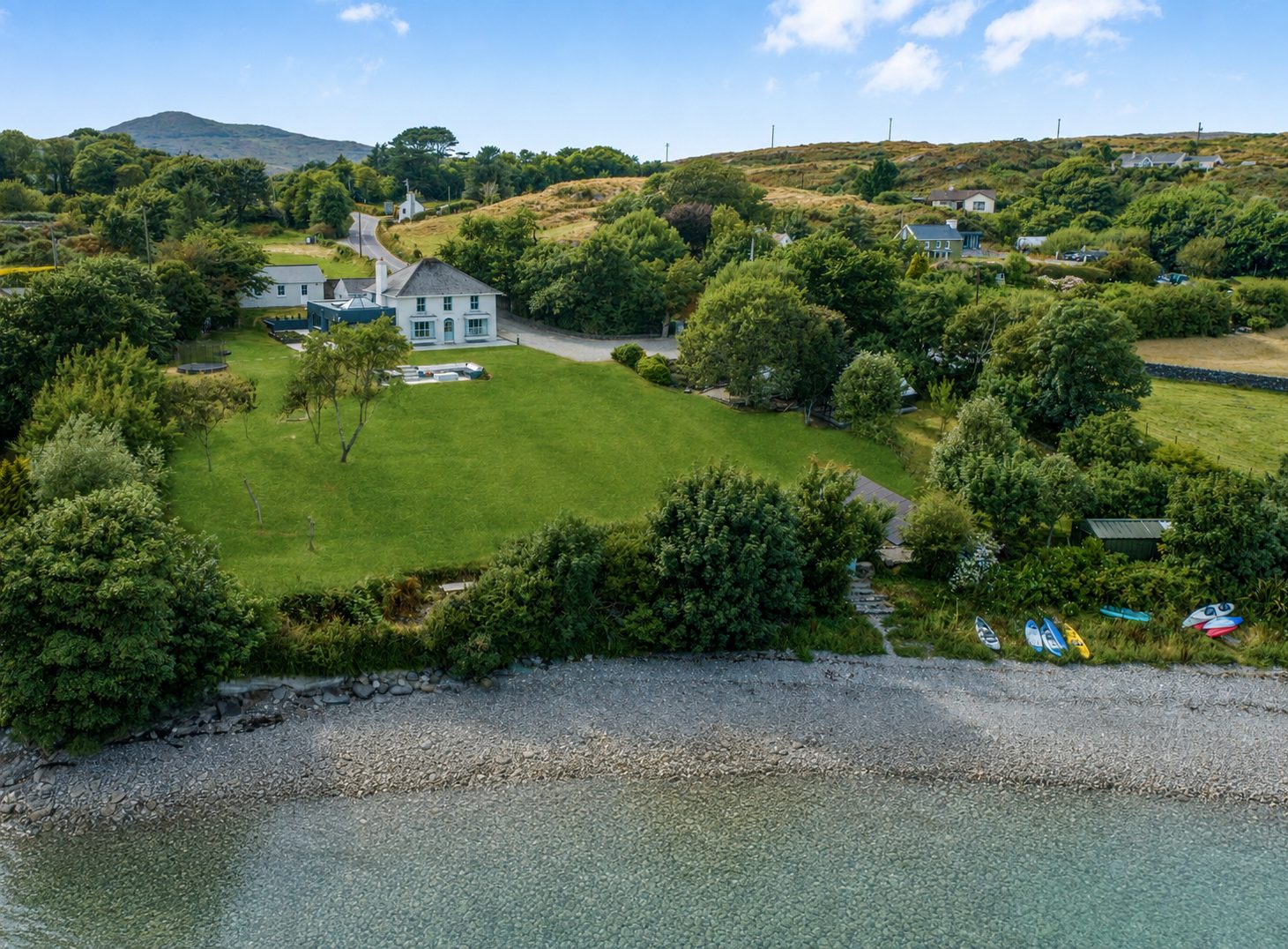 Aerial view of Strandville, its lawn and the shoreline of Toormore Cove